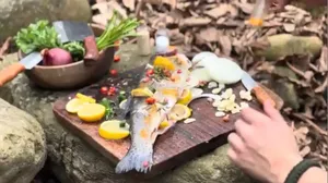 پخت ماهی قزل آلای تازه صید شده زیر زغال داغ در دل طبیعت